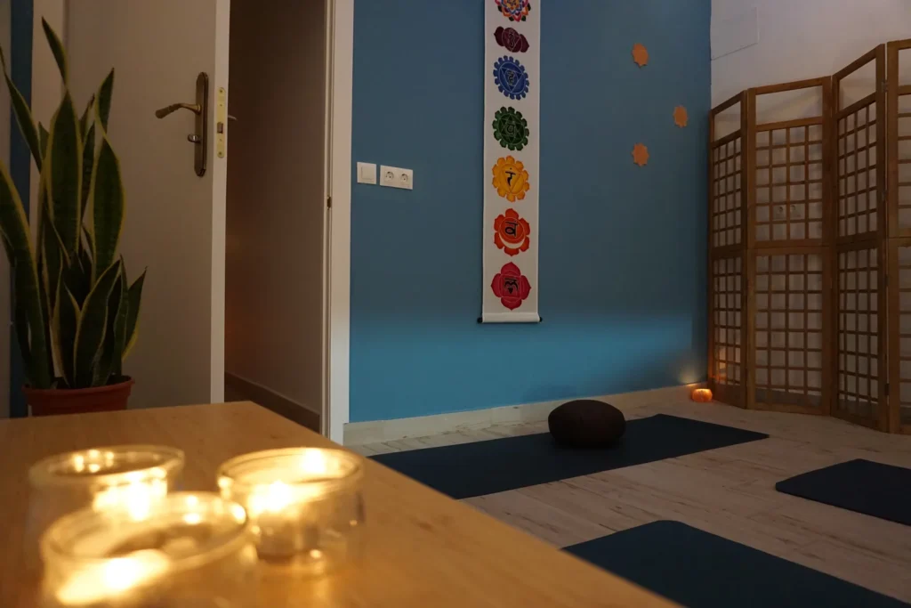 Sala de yoga de Quiroesencia en Granada con esterillas y velas, preparada para una sesión tranquila